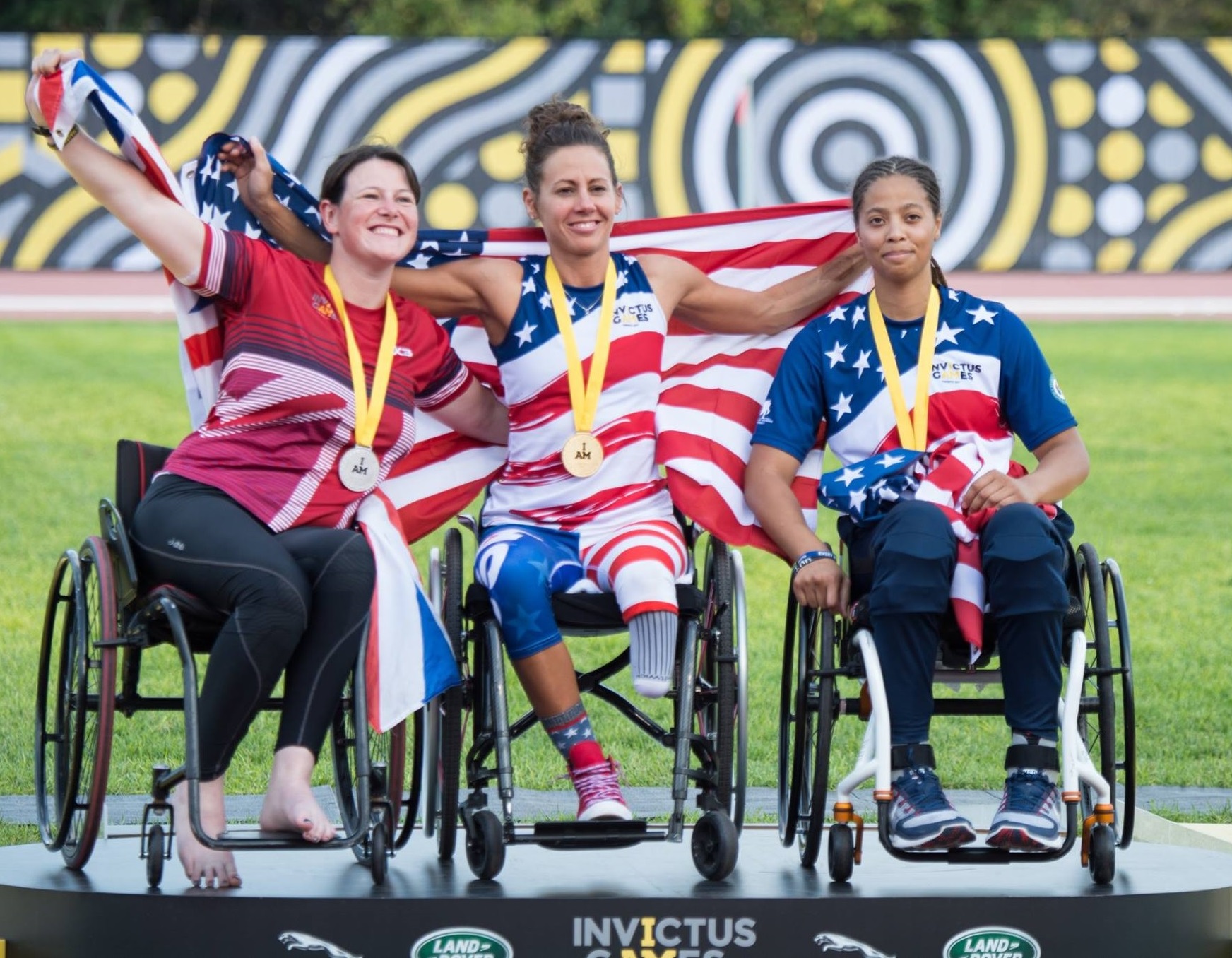 Three American woman on Invictus games podium wearing gold, silver and bronze medals