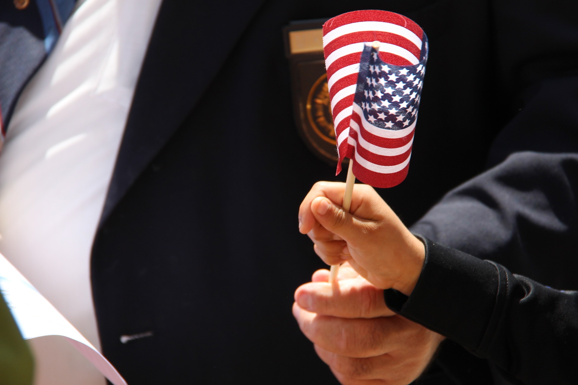 Man and Boy Holding a small stick American Flag